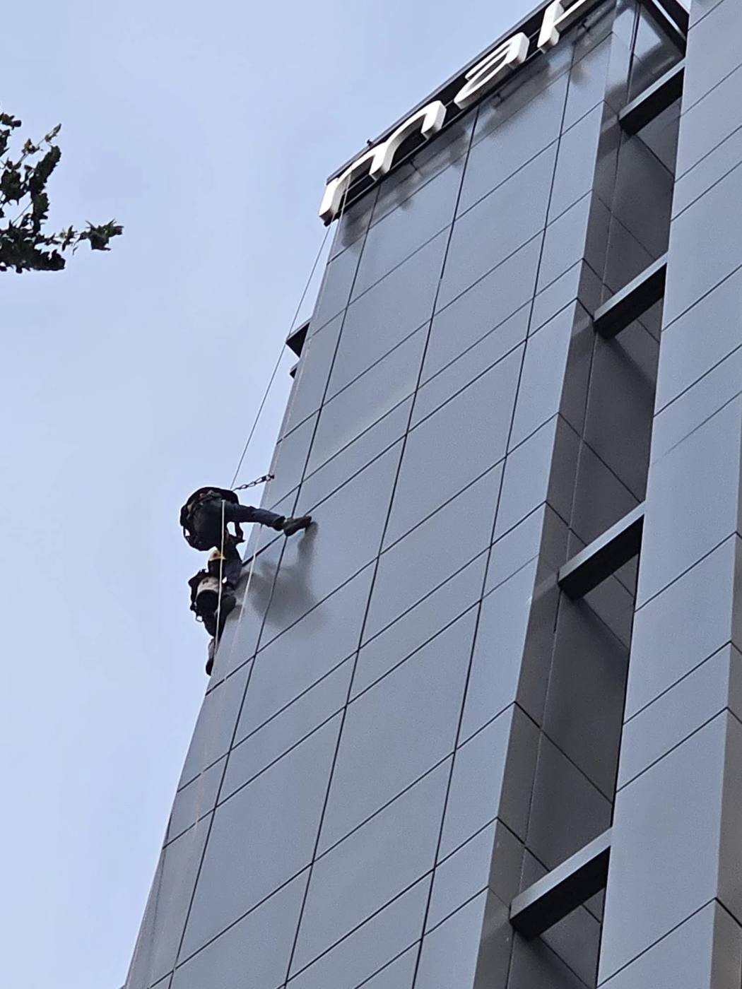 rope access technicians repairing façade cladding on a high-rise in Singapore