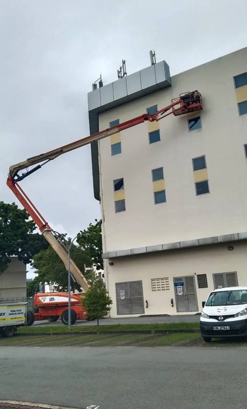 Mobile elevating work platform used for façade coating where it is the better access method in Singapore
