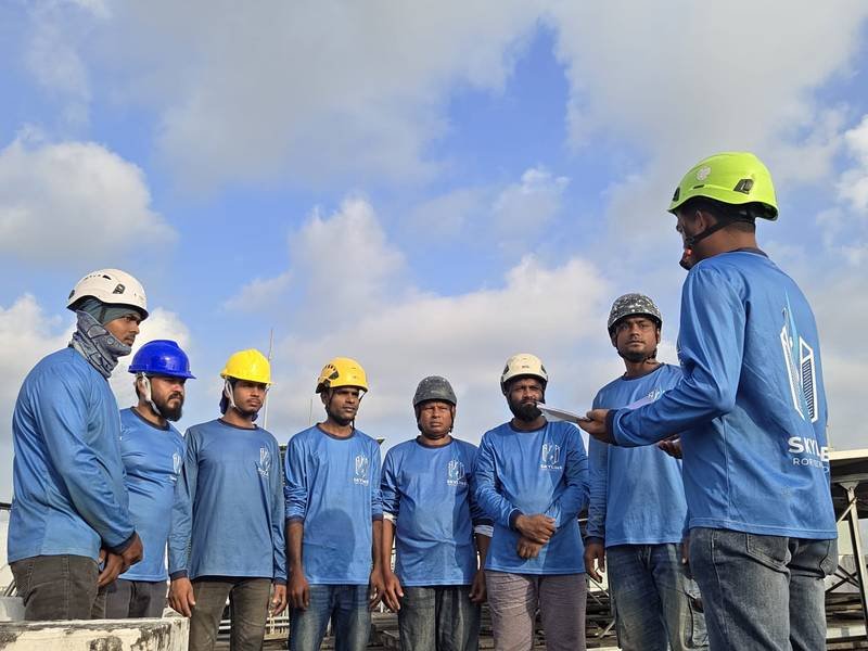 Skyline Rope Tech supervisors briefing the rope access crew on a Singapore rooftop